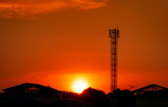 电信塔与红色的日落天空和云广播和卫星波兰沟通技术电信行业移动电信网络轮廓农村房子和森林