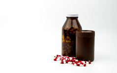 红色的白色抗生素胶囊药片和两个琥珀色的瓶孤立的白色背景与复制空间和空白标签药物电阻抗生素药物使用与合理的健康政策概念
