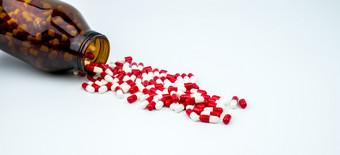 色彩斑斓的抗生素胶囊药片与琥珀色的玻璃瓶白色背景药物电阻抗生素药物使用与<strong>合理</strong>的健康政策和健康保险概念