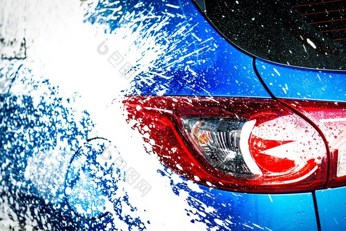 回来视图蓝色的紧凑的运动型多功能车车与体育运动和现代设计洗与肥皂车覆盖与白色泡沫车哪服务业务概念