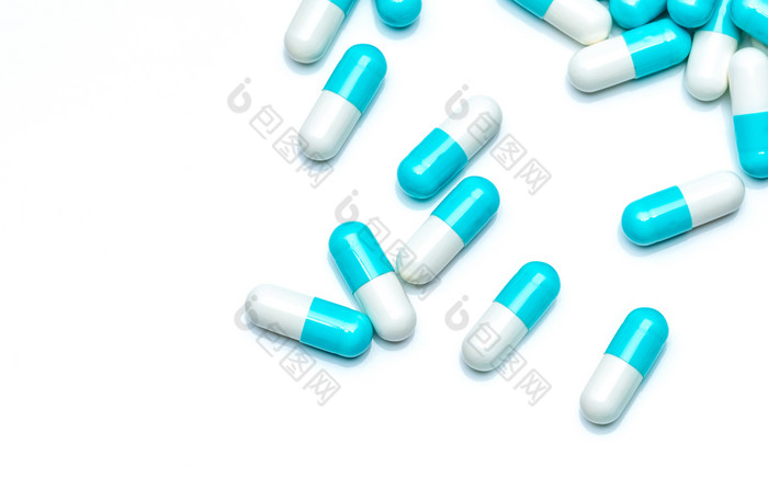 蓝白色胶囊药片孤立的白色背景制药行业和药物市场概念前视图蓝色的柔和的胶囊药片传播白色表格药店产品药物治疗使用