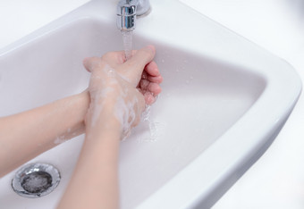 女人洗手与肥皂泡沫和利用水浴室手清洁下水<strong>龙</strong>头水槽为个人<strong>卫</strong>生防止流感和冠状病毒好过程手洗杀了细菌病毒