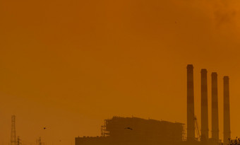 权力植物与橙色日落天空和鸟飞行的天空空气污染概念能源为支持工厂工业房地产权力和能源灰尘传播的空气的晚上