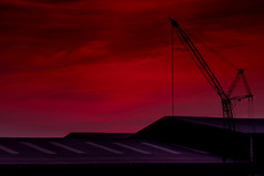 建设起重机对粉红色的天空和云屋顶建筑起重机使用卷电梯设备建设网站起重机为租金起重机经销商为建设业务浪漫的天空