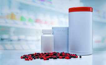 红黑胶囊药片传播计数器药店空白标签塑料药物瓶模糊背景维生素和补充显示架子上药店商店处方药物概念