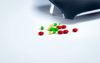 红色的平板电脑和green-yellow胶囊药片与药物托盘白色表格制药行业维生素和补充制<strong>药学</strong>概念药店产品医疗保健和药物治疗