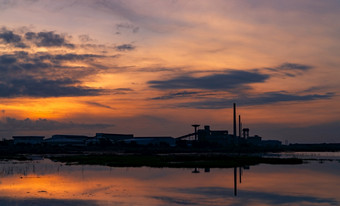 景观工厂行业建筑与黑暗蓝色的和橙色日落天空反射水的河仓库建筑晚上清洁环境周围工厂工厂关闭