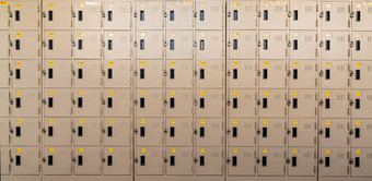 特写镜头米色储物柜与锁和编号黄色的标签储物柜房间储物柜为安全和安全存储行储物柜与锁着的通过背景