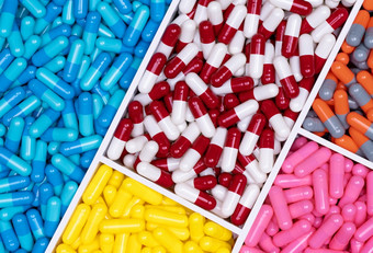前视图<strong>色彩斑斓</strong>的胶囊药片塑料托盘制药行业医疗保健和医学制药学概念维生素和补充胶囊完整的框架明亮的颜色胶囊药片