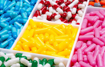 多色的胶囊药片塑料盒子维生素和补充概念制药行业处方药物塑料托盘黄色的粉红色的蓝色的绿色红色的白色橙色胶囊药片