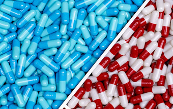 前视图蓝色的胶囊和红白胶囊药片塑料托盘完整的框架两个药物药店药店产品药理学概念医疗保健和医学制药行业