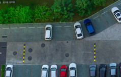 以上视图汽车停车停车区域的公寓空中视图混凝土车停车很多与速度撞附近绿色树的公园户外车停车空间与空槽