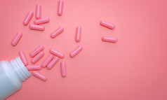 粉红色的胶囊传播出白色塑料药物瓶胶囊和药丸瓶粉红色的背景维生素和补充为健康的皮肤胶原蛋白提高和痤疮治疗概念在线药店