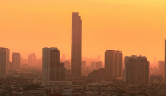 空气污染烟雾和细灰尘覆盖城市的早....与橙色日出天空城市景观与被污染的空气脏环境城市有毒灰尘不健康的空气城市不健康的生活