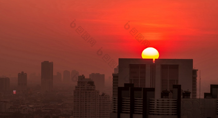 城市景观的早....与日出天空和空气污染细灰尘封面城市城市景观与拥挤的住宅建筑城市日出与大红色的太阳烟雾的空气不健康的