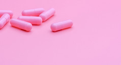 粉红色的胶囊药片粉红色的背景维生素和补充为健康的皮肤使用美诊所为治疗皱纹和痤疮皮肤药店商店网络横幅制药行业快乐药丸