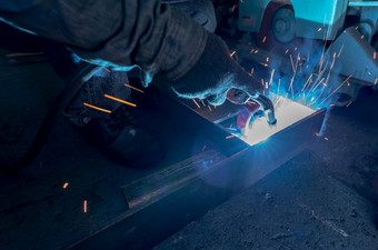 焊机焊接金属与氩弧焊接机和有焊接火花男人。穿保护手套安全工业工作场所焊机工作与安全工人钢行业工厂