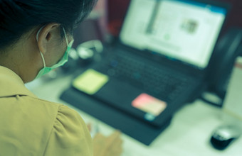 回来视图女人穿脸面具工作桌子上与移动PC<strong>办公室</strong>亚洲女人工人使用电脑<strong>办公室</strong>在工作从首页新正常的生活方式<strong>办公室</strong>后冠状病毒流感大流行