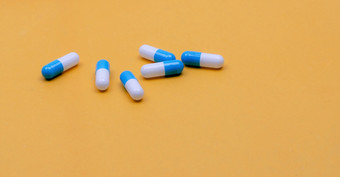 蓝白色胶囊药丸黄色的背景药店横幅胶囊药片制造业行业制药行业药物发展和新药物研究概念胶囊药片行业