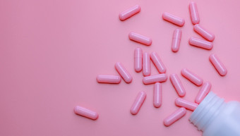 粉红色的胶囊药片传播出塑料药物瓶女人rsquo健康保险和乳房癌症概念维生素和补充为健康的皮肤药店网络横幅在线药店背景