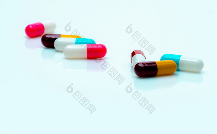 多色抗生素胶囊药片传播白色背景抗生素药物电阻抗菌胶囊药片制药行业粉红色的白色蓝色的黄色的和红色的胶囊药片