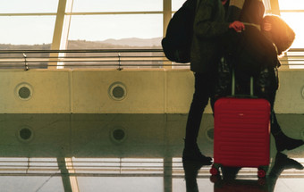 模糊旅游与行李走国际机场航空公司乘客与行李的早....与日出假期旅行在国外和飞行转移概念快乐夫妇旅程