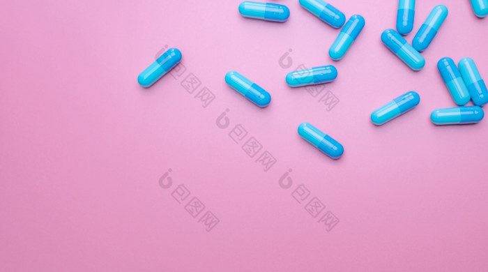前视图胶囊药片粉红色的背景处方药物蓝色的胶囊药片制药行业药和药理学药物发展和新药物研究胶囊药片行业