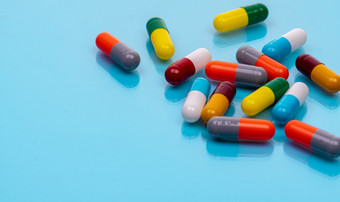 抗生素胶囊药片蓝色的背景处方药物色彩斑斓的胶囊药片抗生素药物电阻概念制药行业超级细菌问题药和药理学