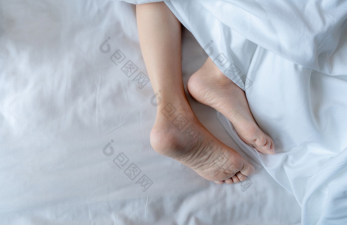 女人光着脚床上下白色亚麻毯子酒店首页卧室健康的睡眠和放松概念懒惰的周日早....只脚女人令人心寒的睡眠白色安慰床上和羽绒被