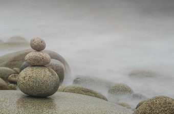 三个鹅卵石堆放的前景多雾的背景与免费的空间为文本Zen概念水平图像卵石堆栈Zen背景