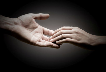 两个手是触碰每一个其他在黑色的背景概念<strong>团结</strong>同理心<strong>团结</strong>