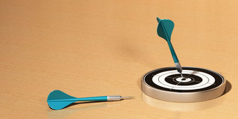 目标和两个飞镖木表格的第一个飞镖打击的中心的目标的飞镖是蓝色的完美的成就目标