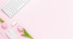 最小的办公室桌子上表格与键盘电脑鼠标白色笔郁金香花橡皮擦粉红色的柔和的表格与复制空间为输入你的文本粉红色的颜色工作场所作文平躺前视图