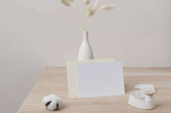 首页室内花装饰彭巴斯草原草表格前面视图空白纸卡问候卡模型美丽的白色彭巴斯草原草花瓶木背景