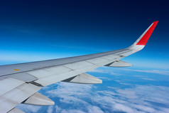 飞机翼在的云蓝色的天空视图从窗口