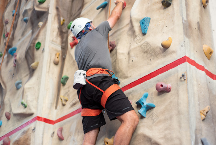 运动男人。练习室内岩石攀爬攀爬健身房运动男人。练习室内岩石攀爬攀爬健身房