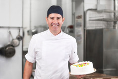 微笑糕点老板显示蛋糕的糕点商店厨房微笑糕点老板显示蛋糕