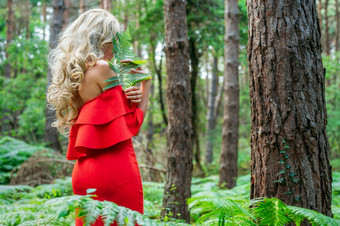 女人红色的衣服持有蕨类植物绿色叶高质量照片女人红色的衣服持有蕨类植物绿色叶