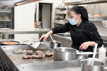 女人老板保护脸面具准备食物的厨房餐厅酒店冠状病毒预防概念高质量照片女人老板保护脸面具准备食物的厨房餐厅酒店冠状病毒预防概念