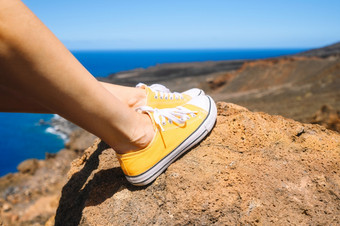 女人放松享受景观旅行者坐着岩石穿黄色的<strong>运动鞋</strong>夏天假期关闭高质量照片女人放松享受景观旅行者坐着岩石穿黄色的<strong>运动鞋</strong>夏天假期关闭