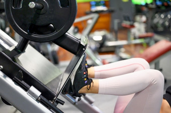 一边视图适合年轻的女运动员弯曲她的腿rsquo肌肉锻炼机的健身房高质量照片一边视图适合年轻的女运动员弯曲她的腿rsquo肌肉锻炼机的健身房