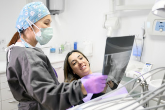女牙医指出病人rsquox射线图像牙科办公室高质量照片女牙医指出病人rsquox射线图像牙科办公室