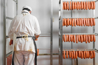 工人挂起生香肠架存储房间肉处理工厂高质量照片工人挂起生香肠架存储房间肉处理工厂