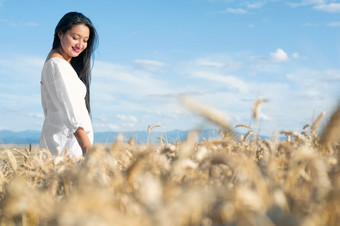 年轻的拉美裔女人白色衣服走的中间小麦场微笑高质量摄影年轻的拉美裔女人白色衣服走的中间小麦场微笑