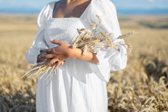 女人白色衣服站场与小麦人持有手包成熟的小穗收获季节高质量照片女人白色衣服站场与小麦人持有手包成熟的小穗收获季节