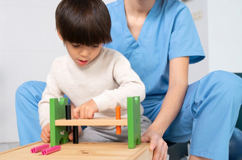 可爱的孩子与残疾玩与发展中玩具而被帮助理疗师康复<strong>医院</strong>高质量照片可爱的孩子与残疾玩与发展中玩具而被帮助理疗师康复<strong>医院</strong>