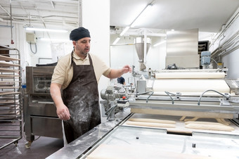 贝克工作工业面包店准备托盘与新鲜的面包高质量照片贝克工作工业面包店准备托盘与新鲜的面包