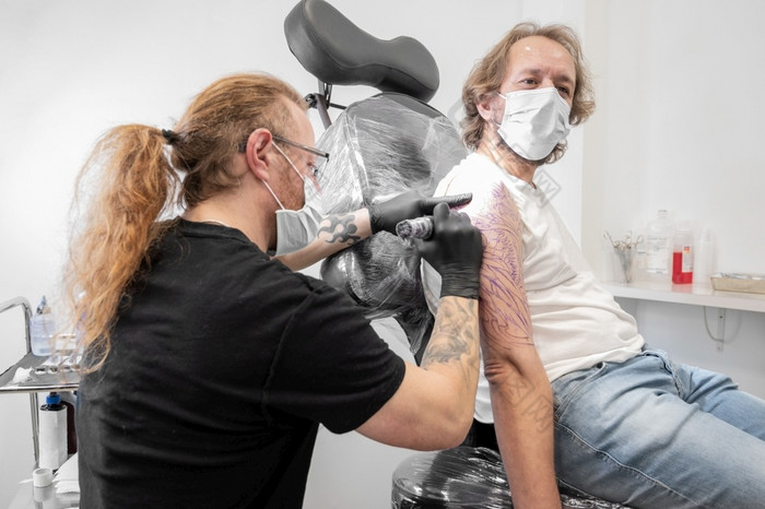 纹身艺术家使纹身的工作室高质量摄影纹身艺术家使纹身的工作室