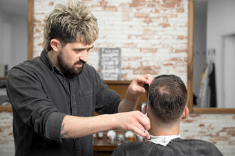理发师切割头发与剪刀<strong>英俊的年轻的</strong>男人。高质量摄影理发师切割头发与剪刀<strong>英俊的年轻的</strong>男人。