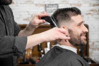 理发师切割头发与<strong>剪刀</strong>英俊的年轻的男人。高质量摄影理发师切割头发与<strong>剪刀</strong>英俊的年轻的男人。